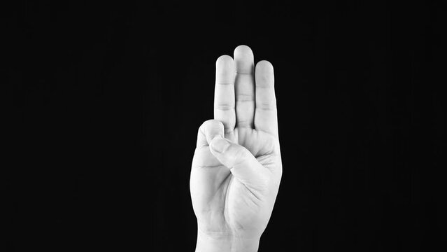 Raising three fingers in monochrome, in studio Chiangmai Thailand.