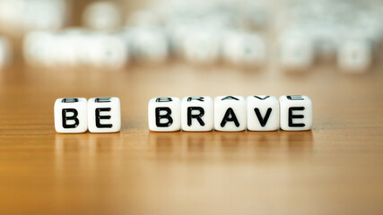 Be brave slogan in white block letter beads 