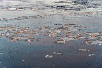 Ice floes in the water, illuminated by the setting sun, as a natural background.