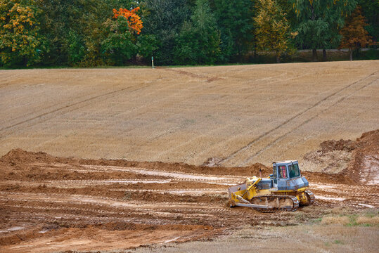 Bulldozer leveling ground on the field, construction work. Road construction, earthmoving on construction site. Bulldozer works. Track-Type tractor for land clearing and heavy dozing. Crawler dozer