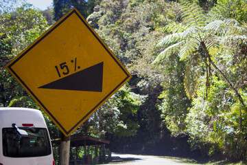 Road sign indicating moderate slope of 15 percent gradient. Moderate upward slope road ahead