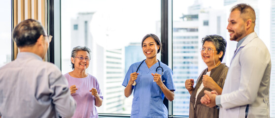 Fototapeta na wymiar Portrait of asian woman physiotherapist trainer carer helping physical and discussing consulting talk with group asian senior patient by doing yoga workout exercises in rehabilitation at hospital