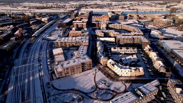 Aerial view of residential complex after a snow storm with Ettegerpark seen from above with rooftops full of solar panels covered in white in urban development of real estate investment project.