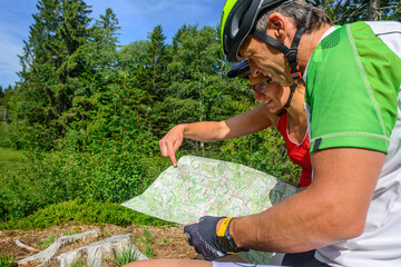 Radfahrer orientieren sich auf einer Landkarte bei einer Tour ins Grüne