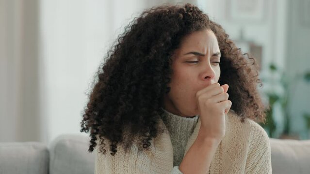 Sick, cough and woman in a home living room with illness and nose rub from virus and covid. Sofa, lounge and sinus problem of a mixed race female with allergies, flu and coughing issue in a house