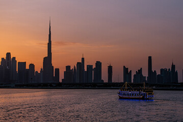 Obraz premium Boat cruise sunset silhouette of Dubai from the Creek 