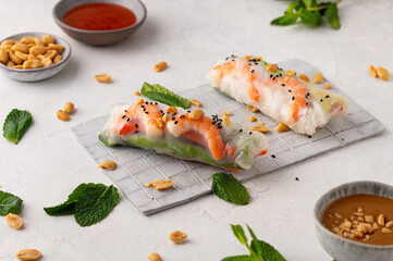 Summer rolls with fresh vegetables and shrimps and peanut sauce. Vietnamese appetizer. Salad spring rolls with prawns. Healthy food concept