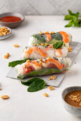 Summer rolls with fresh vegetables and shrimps and peanut sauce. Vietnamese appetizer. Salad spring rolls with prawns. Healthy food concept