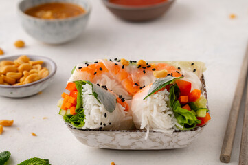 Summer rolls with fresh vegetables and shrimps and peanut sauce. Vietnamese appetizer. Salad spring rolls with prawns. Healthy food concept