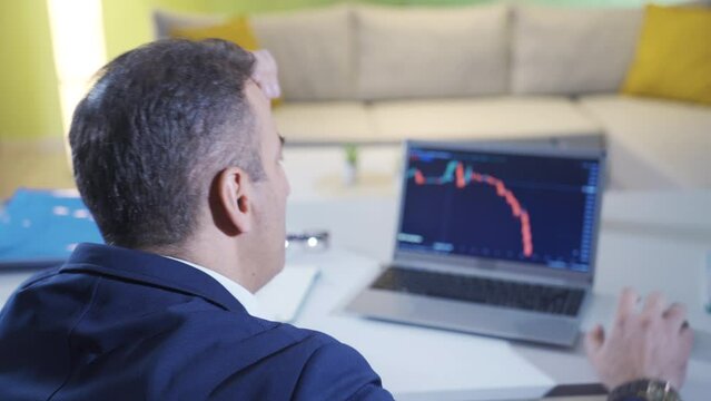 The man who lost in the stock market. The bankrupt man.
Loser man in stock market having nervous breakdown looking at charts on laptop.
