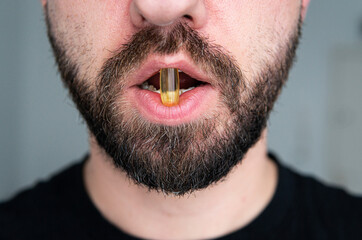 Obraz premium fish oil tablet on the tongue