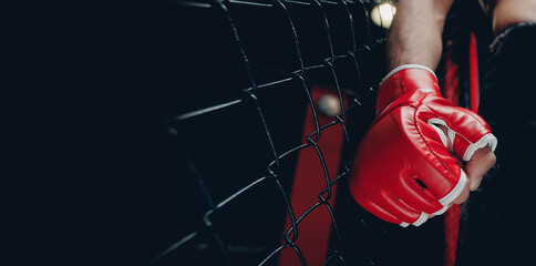 Closeup red Gloves for MMA of Boxers fighter in octagon. Concept sport banner, dark color - obrazy, fototapety, plakaty