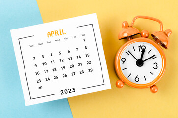 Fototapeta na wymiar The April 2023 Monthly calendar for 2023 year with alarm clock on yellow and blue background.