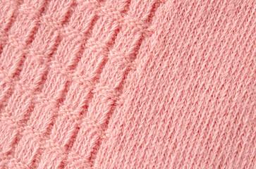 The texture of a knitted woolen pink color cloth. Background.