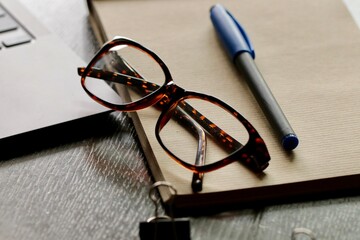 Okulary i notes z pisakiem na biurku. Niezbędne do pracy i biznesu.  Finansowe spotkanie