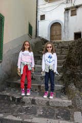 Ritratto di due sorelle gemelle di 8 anni su una scalinata.