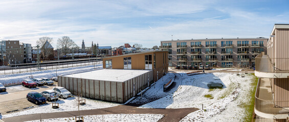 Fototapeta na wymiar Panorama inner square of residential condominium along train tracks covered in snow after a snowstorm. Weather conditions and winter wonderland garden concept