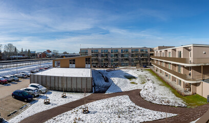 Garden square of residential condominium along train tracks covered in snow after a snowstorm. Weather conditions and Dutch winter wonderland concept