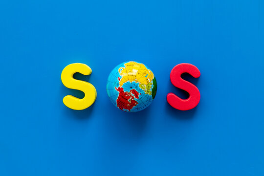 Word SOS made of globe. Save the Earth planet ecology concept.