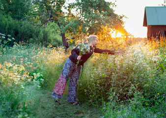 Smiling woman picking wildflowers