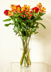 Bunch of alstroemeria and rose flowers in a glass vase