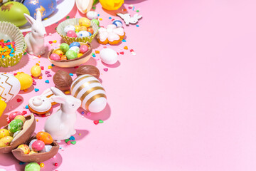 High-colored Easter baking background, Easter sale, party invitation flaylay, Colorful Easter eggs, chocolate eggs and bunny rabbit with sugar sprinkles on bright pink background top view copy space