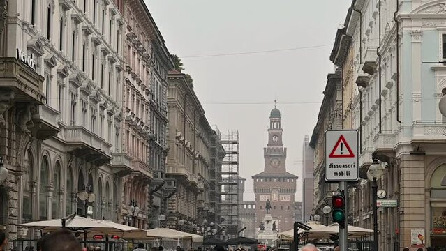 Milan, Lombardy, Italy. February 2023. Slow-motion footage on a typical winter day with gray skies, view of the very central Via Dante crowded with people. Concept of city life, lifestyles.