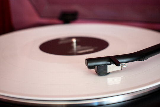 Un vinilo blanco girando en una moderna tornamesa 