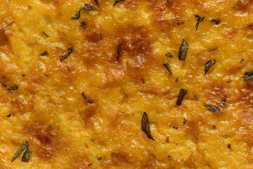 Ligurian Farinata with rosemary close-up background. Baked food texture.