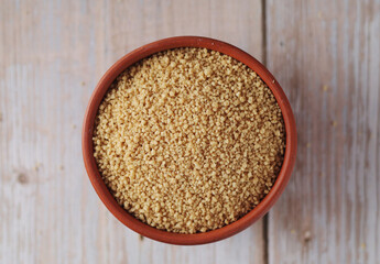 Dry couscous in a small ceramic bowl
