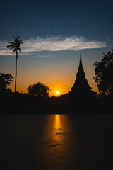 Fototapeta na wymiar Historic Town of Sukhothai temple park, Ancient Buddha Statue at sunset Sukhothai historical park, Mahathat Temple