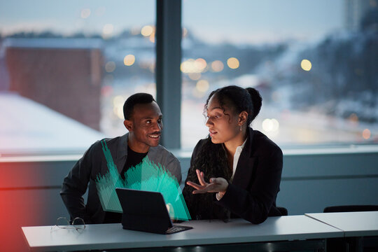 Two young business people working together in office