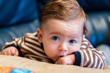 Cute little baby boy resting on a pillow, portrai looking in camera