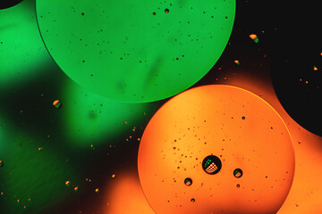 Microbubbles in mixed water and oil background, colorful abstract yellow - green led lights, super-macro abstraction
