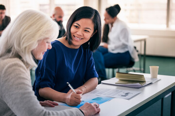 Smiling women sitting together in class