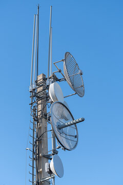 Tower with several round antennas, lightning rods and many cables

