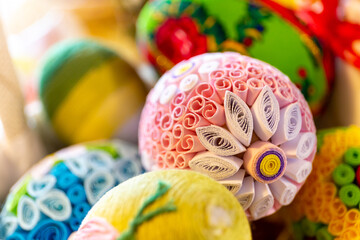 Colorful traditional Easter eggs with floral ornaments, origami decorations and crewel wool,...