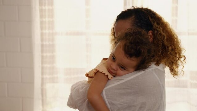 African american mother holding daughter and cuddling with care, family relationship concept
