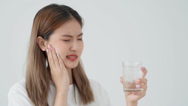 Asian woman feel sensitive teeth after drinking cold, female suffer tooth, decay problems, dental care, tooth extraction, decay problem, bad breath, Gingival Recession, Oral Hygiene instruction