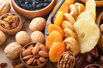 Tu Bishvat celebration concept. Mix of dry fruits and nuts almonds, hazelnuts, walnuts, apricots, prunes, cherries, raisins, dates, apples, figs over wooden table. Jewish holiday, new year of trees.