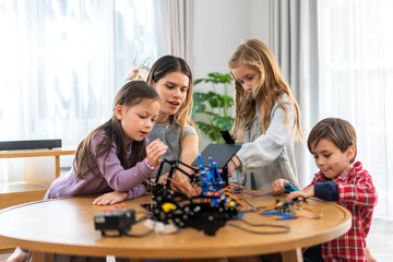Portrait teacher helping school children student having fun activity learn and skill brain training play building with toy STEM education science control robot technology learning class at school