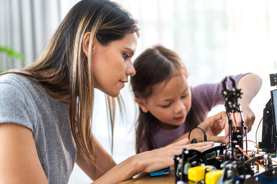 Portrait teacher helping school children student having fun activity learn and skill brain training play building with toy STEM education science control robot technology learning class at school