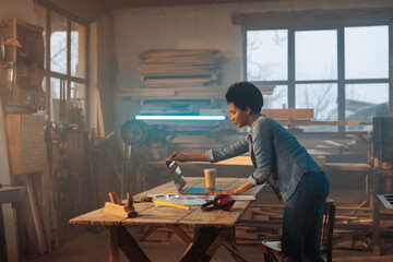 Carpenter using laptop in workshop