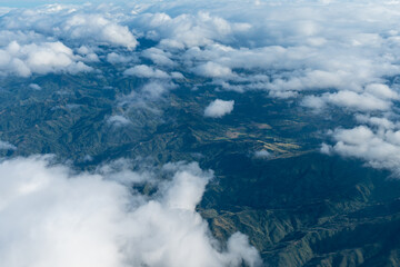 Views of fluffy clouds and complex mountains, pictures taken from the windows on the plane