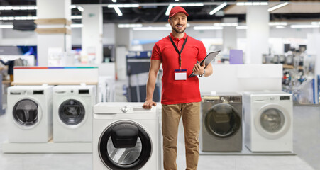 Appliance sales associate leaning on a washing machine in a shop