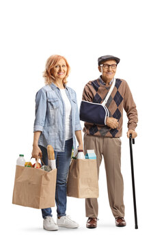 Woman carrying grocery bags for an elderly man with a broken arm