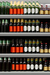 Beer bottles on shelf in supermarket with brand less labels. Suitable for presenting new beer bottles and new designs of labels among many others. 