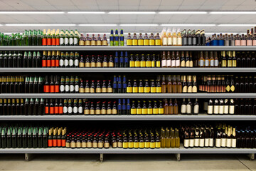 Beer bottles on shelf in supermarket with brand less labels. Suitable for presenting new beer bottles and new designs of labels among many others. 