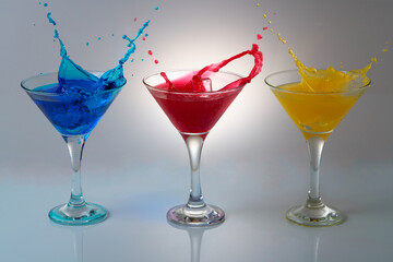 A colorful composition of cocktails with splashes. Conical glass cups.