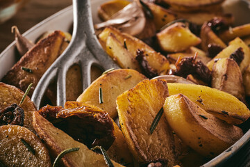 Spatula inside pile of fried potato slices